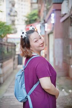 穿紫色衣服的人在街道边走描述已自动生成